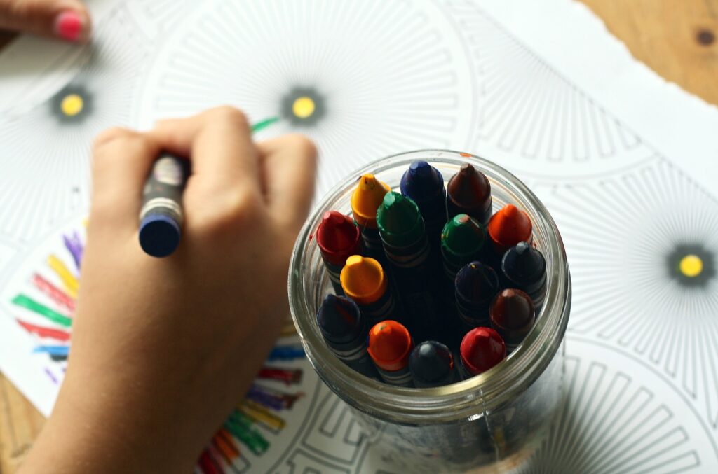 Close up of child using crayons to draw