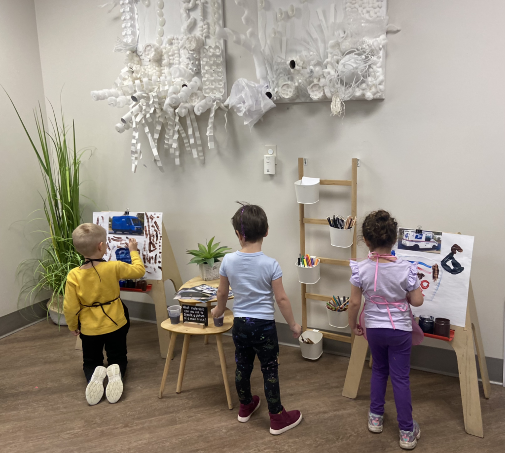 Three children painting on art easels