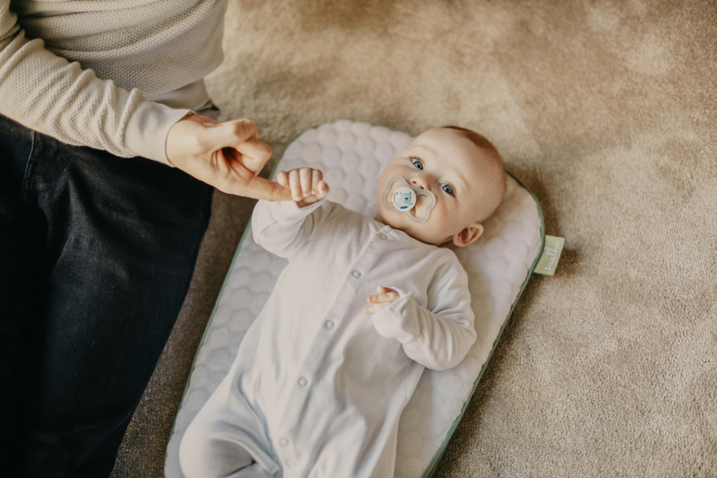 Infant holding mothers hand