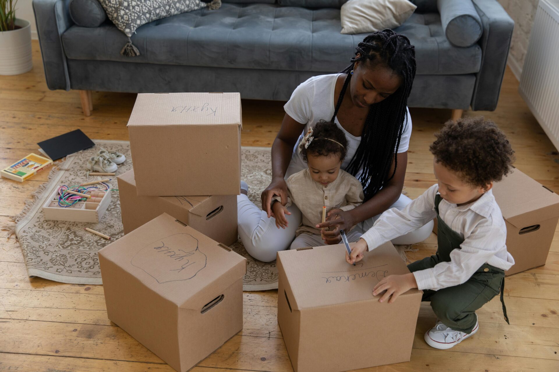 Family with preschooler and young child packing moving boxes.