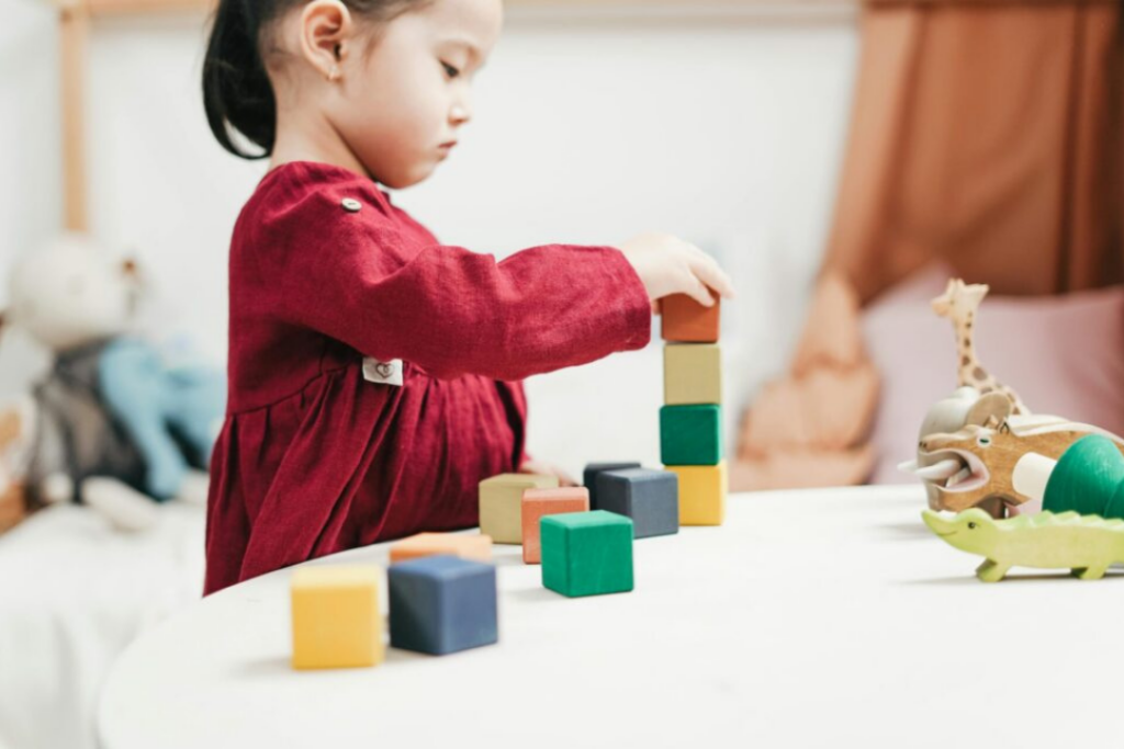 Child building with blocks, illustrating the steps to build better parent-teacher partnerships.