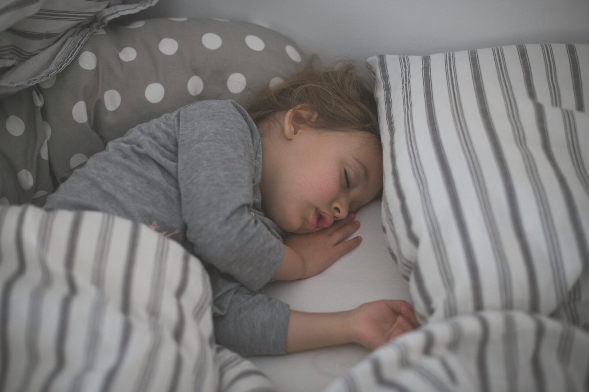 Child peacefully asleep in bed, illustrating a healthy sleep routine.