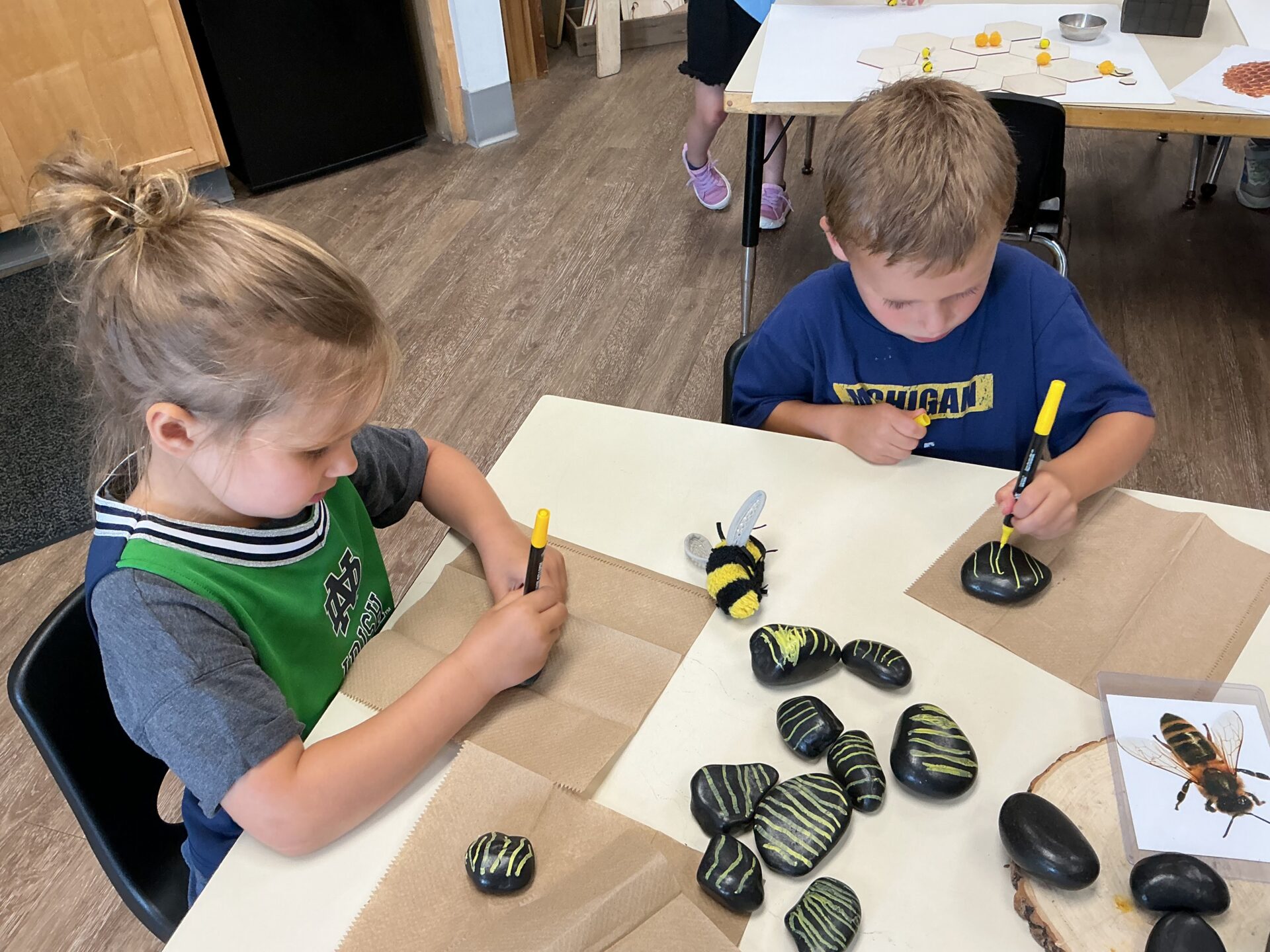 Children’s Discovery Center students creating “bees” from rocks in a Reggio Emilia lesson